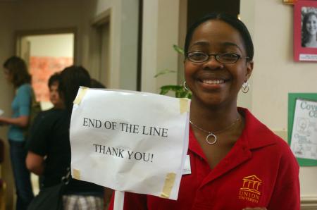 Reneé Jones of career services holds a sign up for students to know where exactly the end of the line is as she stands in the McAfee commons.