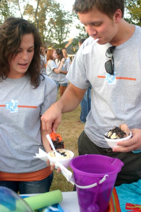 Freshmen Hannah Harvell, an MK from the Phillipines, and Trey Wilcox spread chocolate chips on their ice cream during the annual ice cream social at the home of President Dockery.