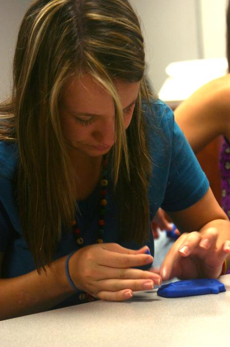 Mikaela Owens-Hughes works on a Play-Dough sculpture in her Focus group that will describe some aspect of her life.