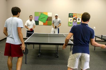 Jacob Hodge and David Hollsinger, back center, play intramural ping pong for SAE against Preston Davis and Ryan Davis.