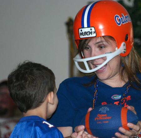 McAfee Residence Director Ashley Jackson and her son, Matthew, cheer on University of Florida in a game against University of Tennessee as they watch it projected on a wall in the McAfee Commons.
