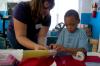 9/27/07 - Kathleen Cooper helps a boy with a paper towel rocket at a Boys and Girls Club.  - Neisha Fuson