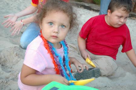 Armando (right) and his little sister sit in the sand pit during the Make-A-Wish Foundation party held for Armando by Chi Omega. 