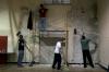 Members of SAE fraternity: (from left) Scott Goff, Jeff Norris, Casey Kidd and Luke Burleson work on stripping paint off one of the gym walls at the Augustine school to prepare for a fresh coat of paint during Day of Remembrance. - Photo by Kyle Kurlick
