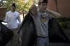 Scott Riessen, right, and Tyler Merriam, left, carry leaf-filled garbage bags to the dumpster at the Augustine School where they and fellow SAE members are spending Day of Remembrance cleaning the grounds of the school. - Photo by Kyle Kurlick