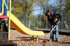 Freshman Cherish Cooper rakes wood chips to cover mud holes on a playground set at Whitehall Elementary School during Day of Remembrance. - Photo by Stephanie Schroeder