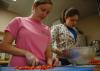 Sophomores Jillian McQueen and Courtney Bragg cut up some tomatoes during Day of Remembrance for a J-Crib Ministry banquet.  - Photo by Neisha Fuson