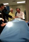 Alums were able to test the simulator mannequin under Mark Kossick's instruction at the School of Nursing's homecoming reception. - Photo by Kristi McMurry