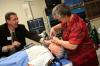 Mark Kossick helps Melanie Matthews perform a procedure on a simulation dummy at the School of Nursing's homecoming reception. - Photo by Kristi McMurry