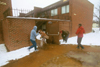 Several students ambush a student with snowballs before he runs back into Watters Complex. - Photo by Justin Veneman