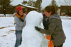 Freshmen Beth Pierce and Cindy Keegan work hard at building their first snowman for the year 2003.   - Photo by Kristen Hiller