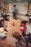 Assignment: Alison Oshel/Student Teacher - It is time for a time test and Shelby Hibner, Myah Floyd and Harley Storey pull out their offices in order to prevent cheating while Oshel prepares for the next lesson. - Photo by Lindsay Stavish