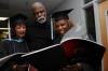 Marilyn Locke, left, and her fiancé Pierre Nelson both of Memphis, along with Portia Brown, also from Memphis, look over the graduation program moments before service begins. Locke and Brown received the Masters of Arts in Education degree during the summer graduation at Union University. - Photo by Jim Veneman