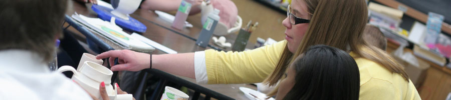 Paige Ward helps a student with her pottery assignment at Madison Academic.