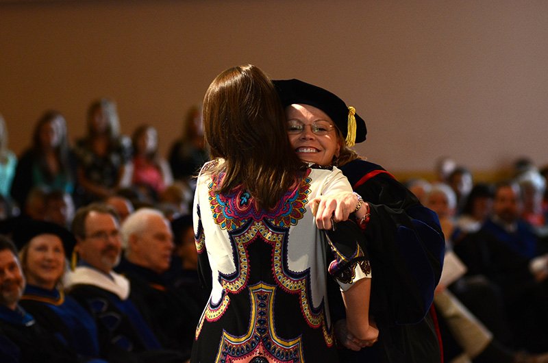 Amanda Rutland gets a hug from Dr. Heckler after being presented with the Academic Excellence in Family Studies award from Dr. Dockery. 
