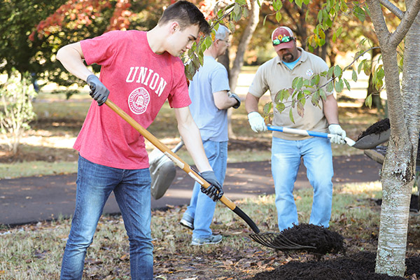 student working in a flower bed