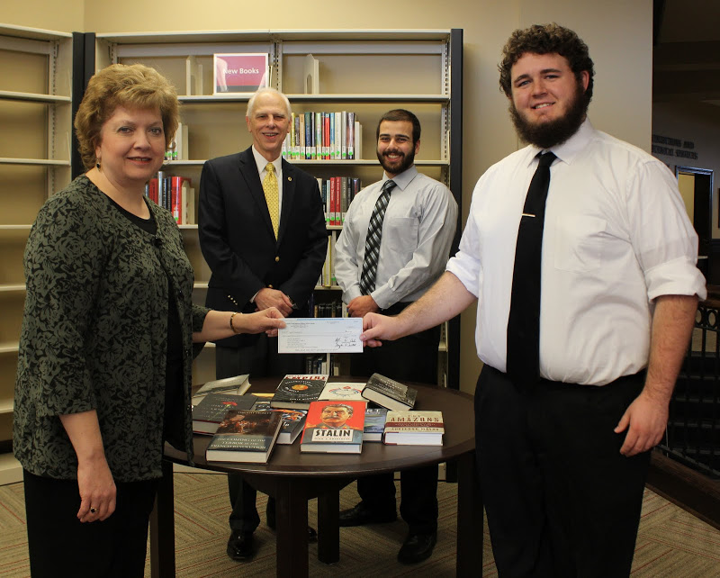 Phi Alpha Theta Chapter President Nick Hancock (right) presents a Best Chapter Award check to Library Director Anna Beth Morgan at a special ceremony in Union's library on December 3, 2015. In the background are Delta-Psi Chapter Faculty Advisor Dr. Stephen Carls (left) and Vice President Allen Bradley.