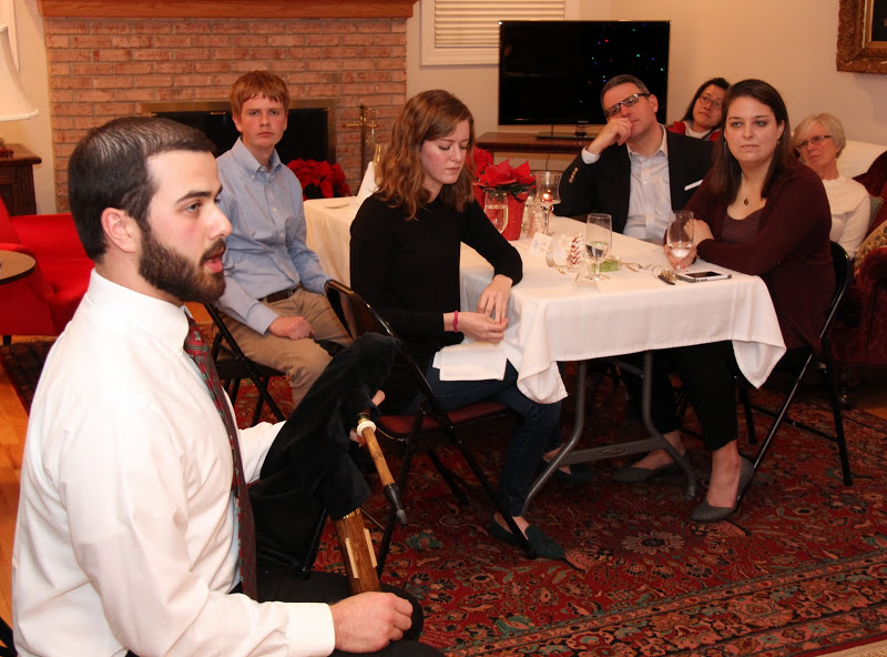 Allen Bradley explains how his interest in playing bagpipes began during a question and answer session at the Franco-American Christmas dinner on December 5, 2015. He is holding a set of shuttle pipes. Seated at the table behind him are (left to right) Gideon Ragland, Beth Adams, Dr. Keith Bates and Emily Littleton.