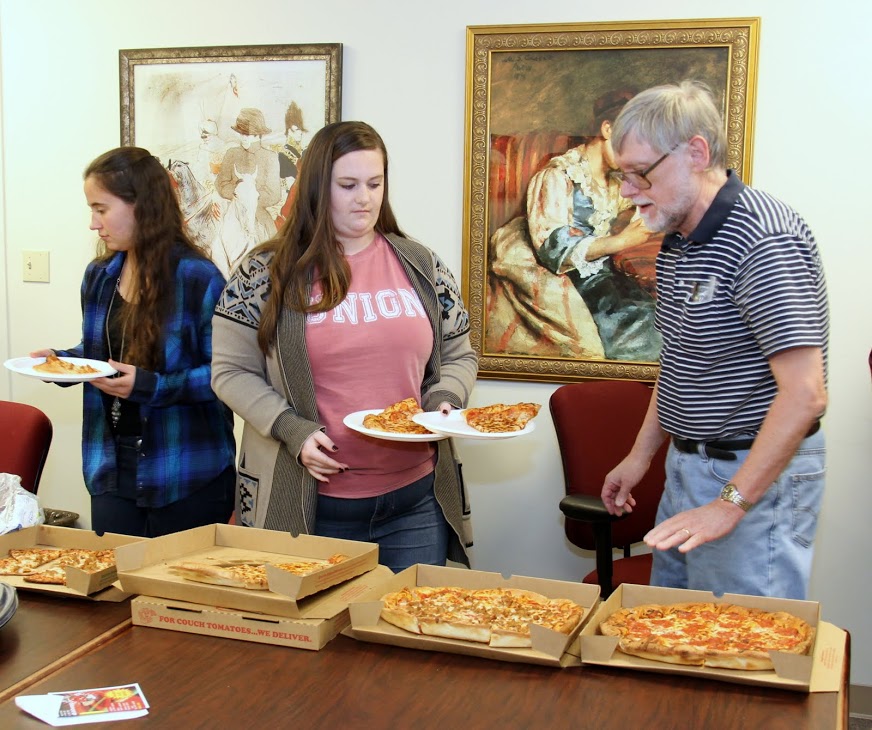 Joanna Butcher (left to right), Sarah Burdick, and Dr. Terry Lindley check out the pizzas available at the history club's movie night on December 2, 2016.