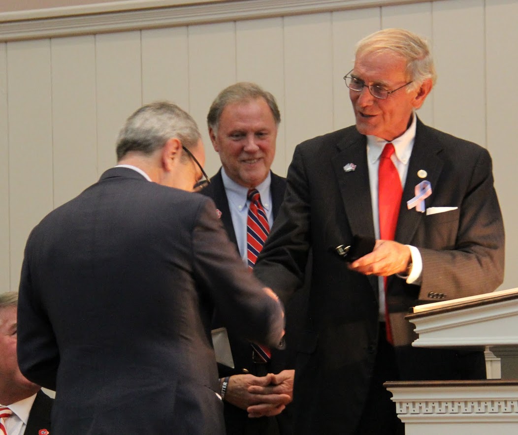 City of Jackson Mayor Jerry Gist (right) presents Consul Général de France Louis de Corail (back to the camera) with a key to the City of Jackson and a set of cufflinks with the city's seal on them at a Great War commemoration program on November 4, 2016. Behind Mayor Gist is Madison County Mayor Jimmy Harris.
