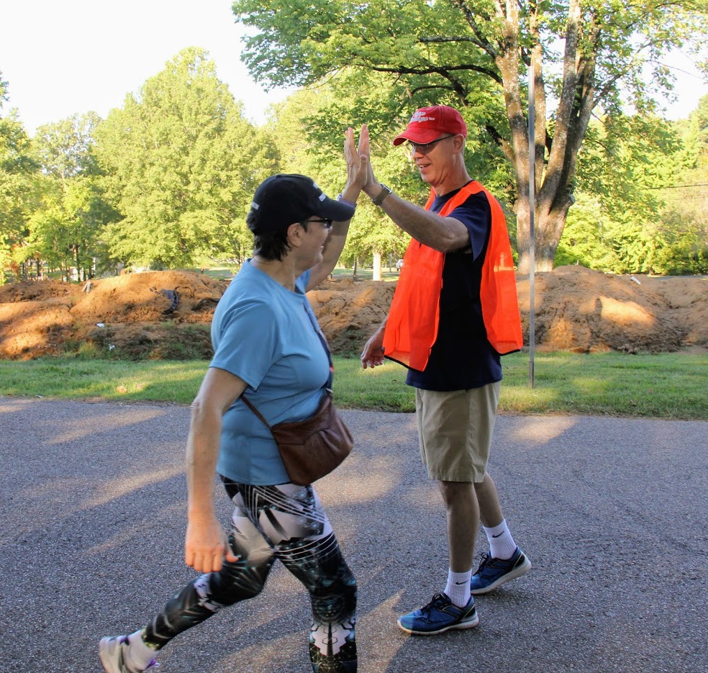 Dr. Alice-Catherine Carls and Robert Briley do a high five as she participates in the Racing So They Can Ride 5k event on September 15, 2018.