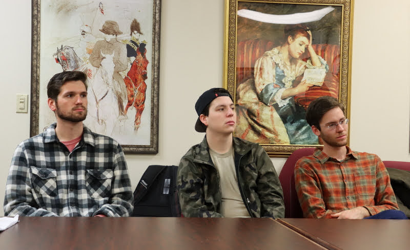 Student attendees listen to Jack Waters present highlights of his history honors thesis on December 8, 2021. They are (left to right) Jake Guyette, Nicholas Bitterling, and Matthias Hargrave.