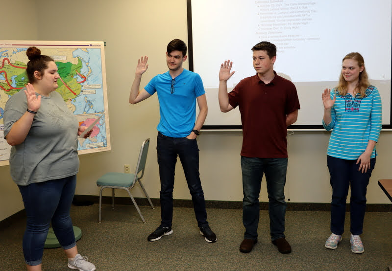 Rutledge Honorary History Club President Sandra Allen conducts the initiation ceremony for three new club members on October 7, 2021. The new members are (left to right) Seth Blair, Noah Kea, and Anna Guelcher.