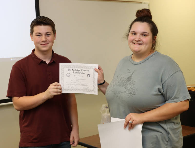 Noah Kea receives his Rutledge Honorary History Club membership certificate from President Sandra Allen at the club's plenary meeting on October 7, 2021.