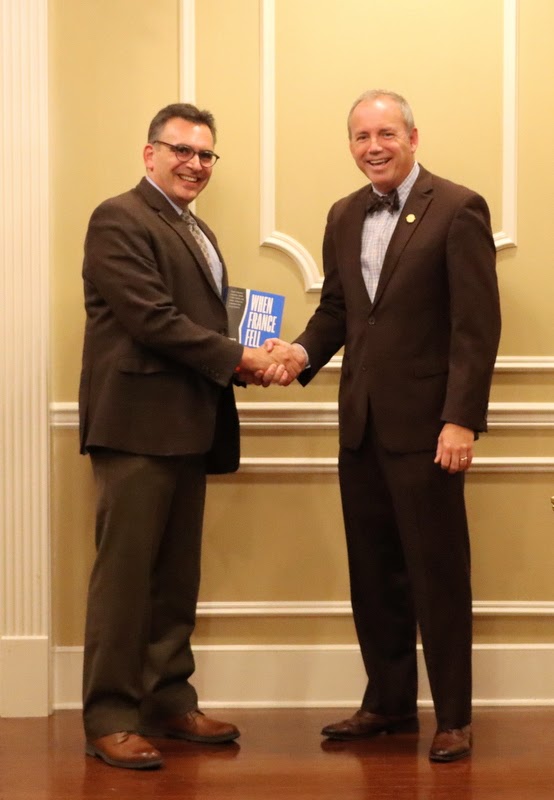 Dr. Michael Neiberg (left) presents a copy of his book WHEN FRANCE FELL to Union University President Dr. Dub Oliver at a dinner in Professor Neiberg's honor on October 24, 2022.