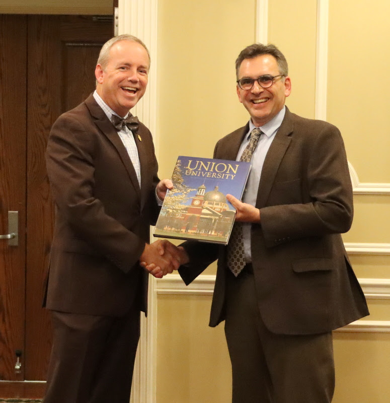 Union University President Dr. Dub Oliver (left) presents a copy of the university's bicentennial book to Dr. Michael Neiberg during a dinner in Professor Neiberg's honor on October 24, 2022.