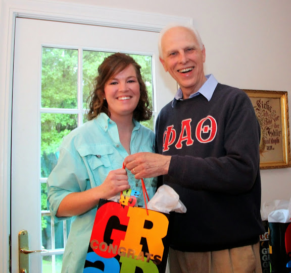 Sarah Carroll, a graduating Phi Alpha Theta member with a double major in history and political science, accepts a graduation award bag from Dr. Stephen Carls at the annual Phi Alpha Theta cookout on May 8, 2015.