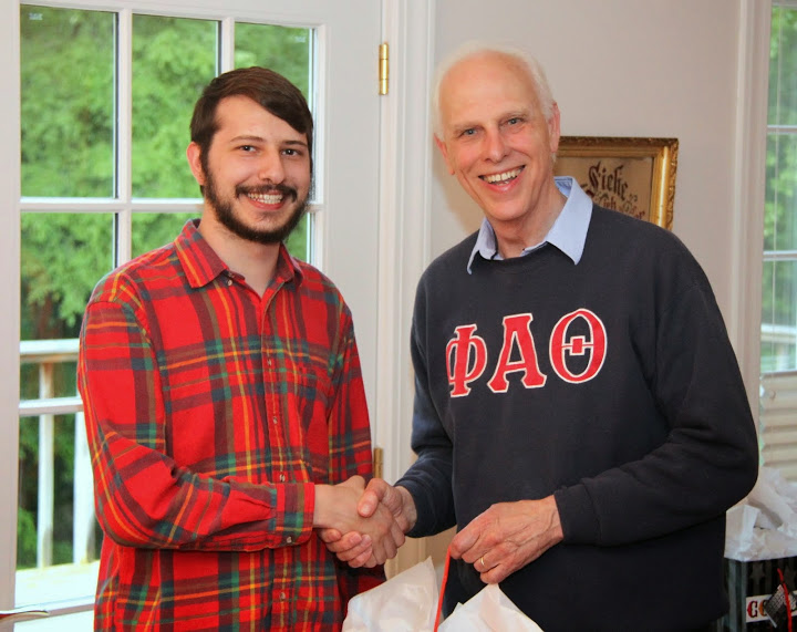Graduating Phi Alpha Theta member Hunter Hawes receives congratulations and an award bag from Dr. Stephen Carls at the 23rd Annual Phi Alpha Theta/History Department Cookout on May 8, 2015.