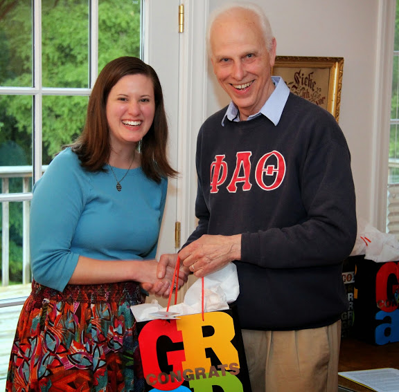 Graduating Phi Alpha Theta member Kayla Ketner accepts congratulations and a graduation award bag from Dr. Stephen Carls at the society's annual cookout on May 8, 2015.