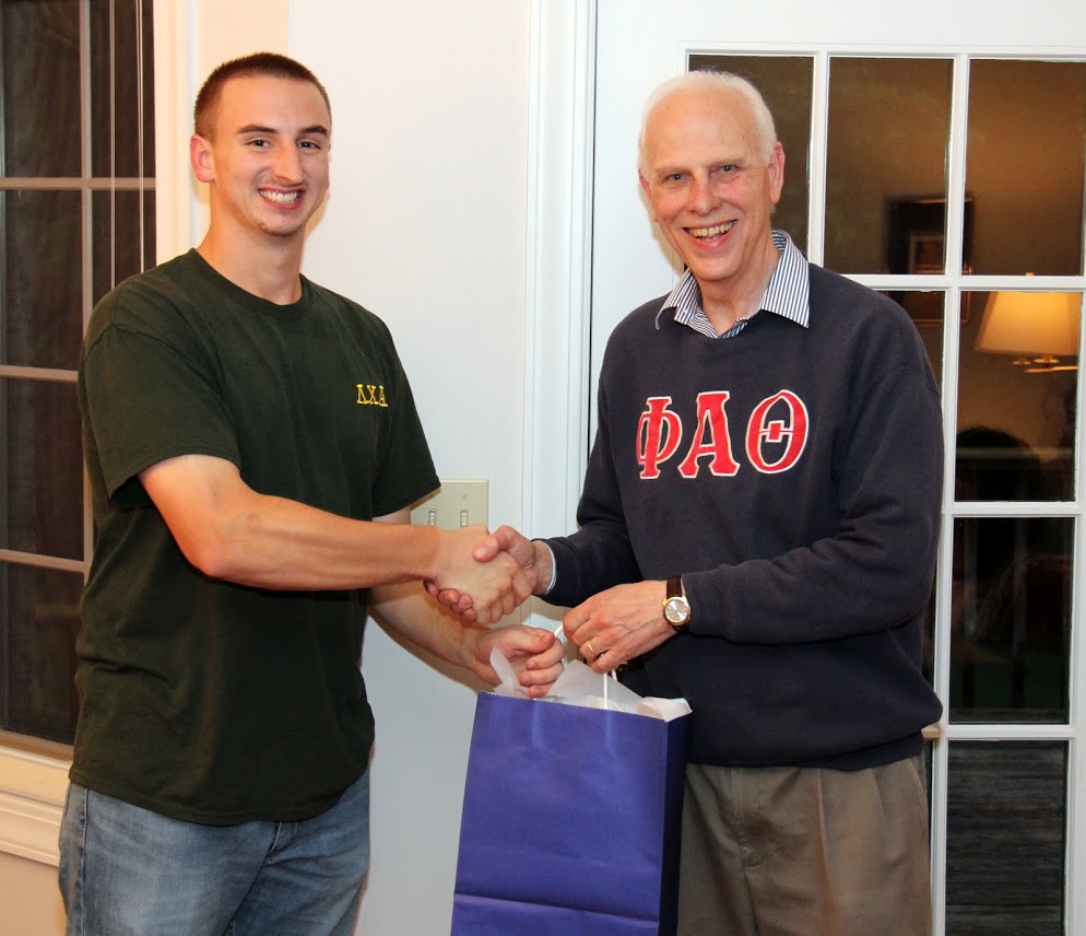 Graduating history major Jeff Williams (left) receives an award gift and congratulations from Dr. Stephen Carls at the history department's cookout on May 12, 2017.
