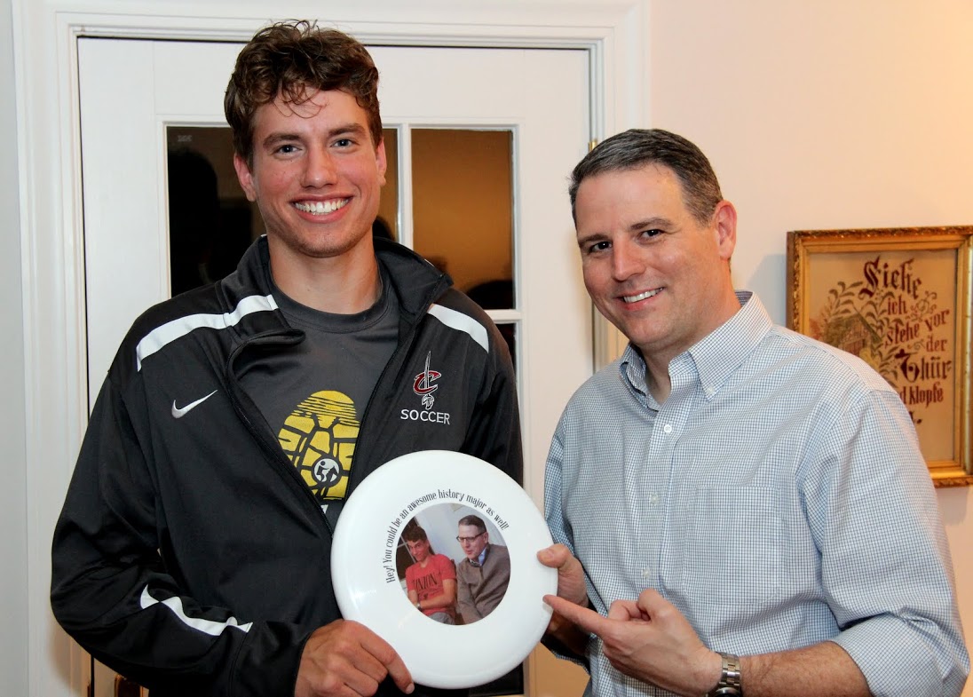 Stephen Lewoczko (left) and Dr. Keith Bates show off a frisbee at the Phi Alpha Theta cookout on May 12, 2017, that contains a picture of the two of them from an outing in the fall of 2016.