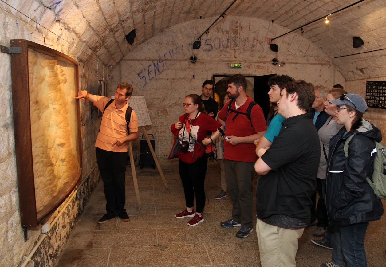 Tour guide Guillaume Moizan (left) uses a map on May 27, 2018, to explain the 1916 Battle of Verdun to the UU-UTM travel group as he takes them through Fort Douaumont, the largest in a series of French forts that protected the city of Verdun from attack. The Germans captured the fort three days after the battle began in February; the French recaptured it in late October.