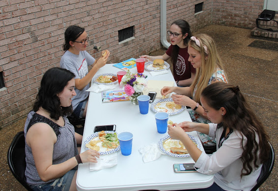Attendees at the history department cookout on May 12, 2018, enjoy good food and conversation. They are (left to right, going clockwise) Lydia Black, Lillie Salazar, Lauren Butler, Ali Renckens, and Joanna Butcher.