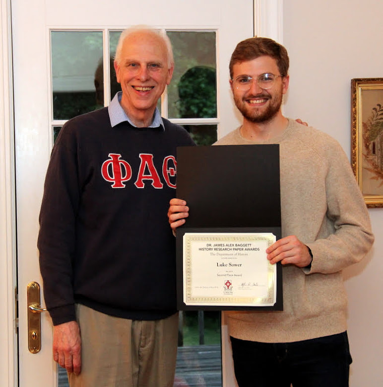 Luke Sower (right) accepts the second-place award in the Dr. James Alex Baggett History Research Paper Competition from Dr. Stephen Carls at the history department cookout on May 11, 2019.