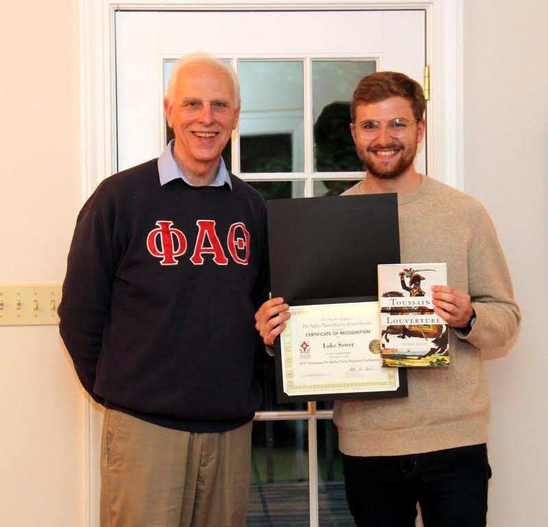Luke Sower (right) stands with Dr. Stephen Carls after receiving a certificate of recognition and a book at the history department cookout on May 11, 2019, for his paper presentation at the Tennessee Phi Alpha Theta Regional Conference at Belmont University in March.