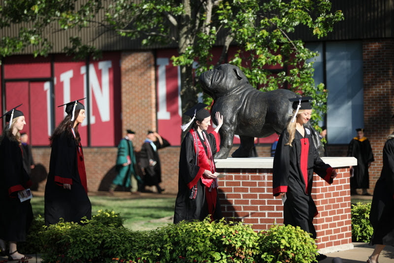 Graduating history major Lauren Butler touches the bronze statue of Buster the Bulldog during the processional of Union University's undergraduate commencement service on May 18, 2019. Photo by Kristi Woody