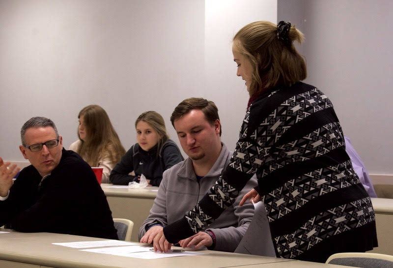 Delta-Psi Vice President Megan Ledbetter distributes Phi Alpha Theta information to attendees at the chapter's plenary meeting on February 25, 2020. In the front row are Dr. Keith Bates (left) and Macon Bullock. Visible in the back row are Hannah Ratliff (left) and Addison Osborne. Photo by Naomi Mengel