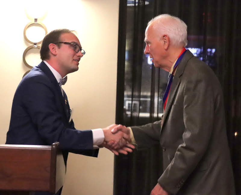 Dr. Jacob Blosser congratulates Dr. Stephen Carls at the end of Carls's induction as an honorary Dean of Phi Alpha Theta on January 4, 2020. The ceremony took place during the Presidential Banquet of the society's biennial convention.