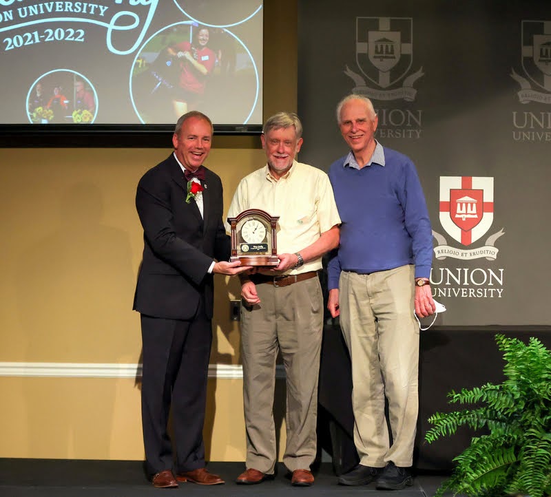 Dr. Terry Lindley (center) accepts a clock from Union University President Dr. Samuel W. 