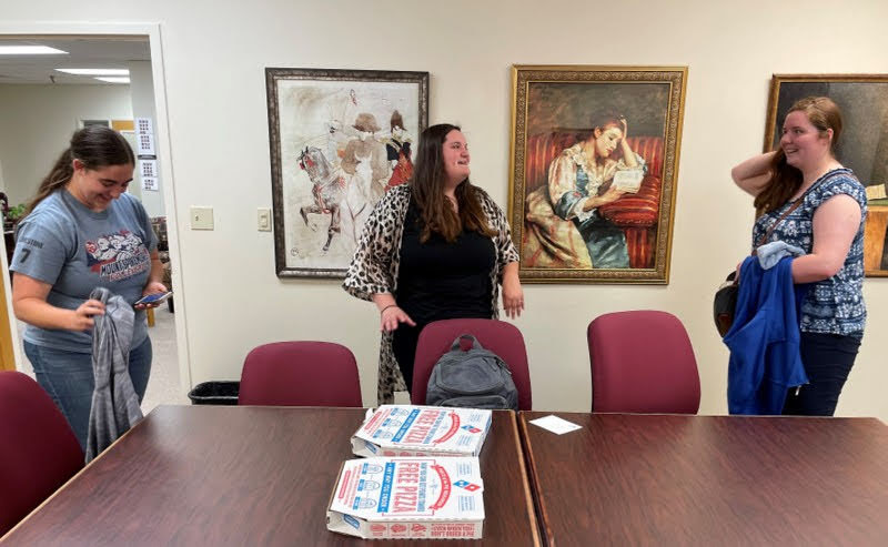 History Club members get ready to enjoy some pizza at the club's movie night on May 5, 2022. They are (left to right) Joy Brown,  Sandra Allen, and Abigail Gilbert. Photo by Henry Allen