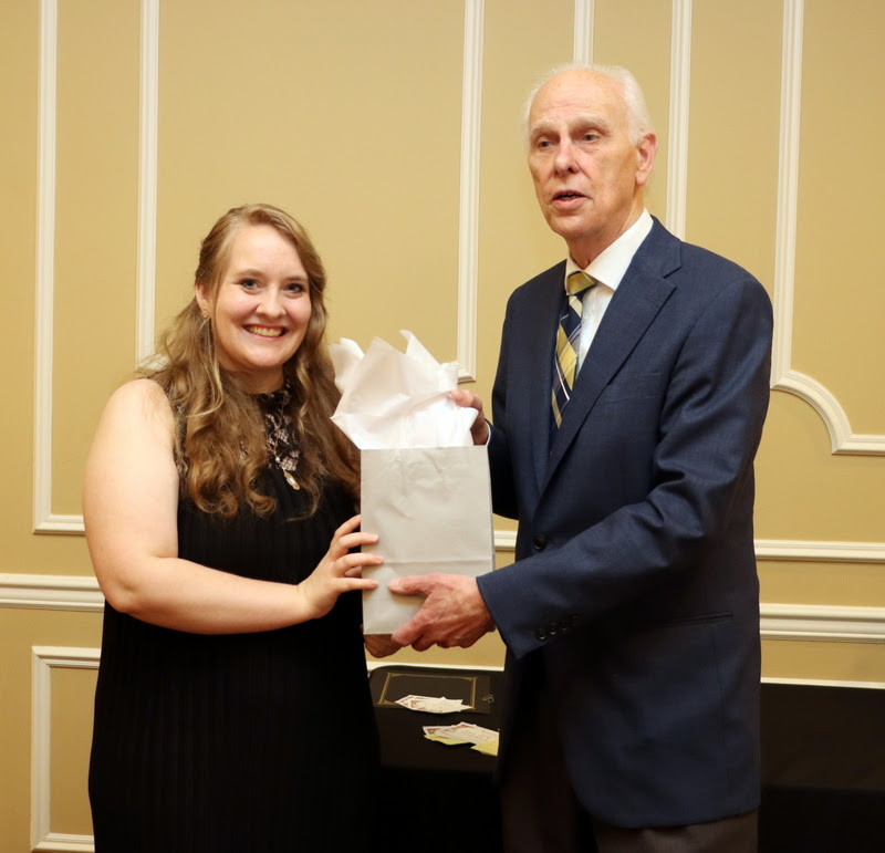 Graduating history major and Phi Alpha Theta member Breanna Edmiston receives a history gift award bag from Dr. Stephen Carls at the History Department Awards Banquet on April 27, 2023.