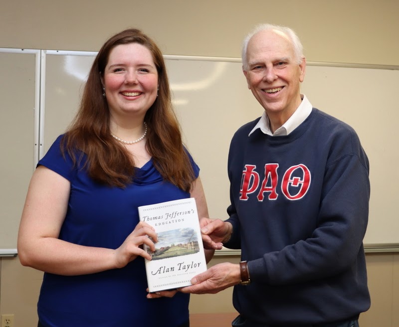 Dr. Stephen Carls presents a history book to Abigail Gilbert at the Delta-Psi chapter's spring plenary meeting on February 20, 2023. Gilbert was honored at the meeting as the chapter's 500th inductee since the chapter received its Phi Alpha Theta charter in 1953. Dr. Alan Taylor, the book's prize-winning author, will serve as the Carls-Schwerdfeger History Lecturer on October 16, 2023.