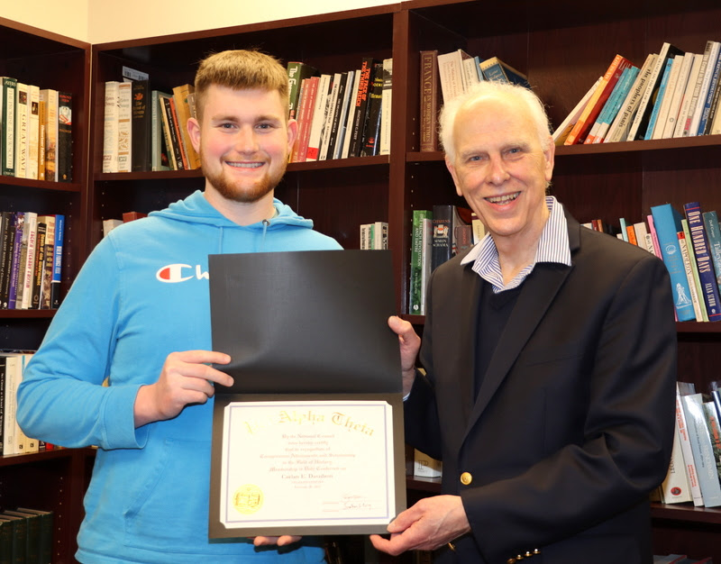 Caelan Davidson receives his Phi Alpha Theta membership certificate from Dr. Stephen Carls in a special induction ceremony on February 24, 2023.