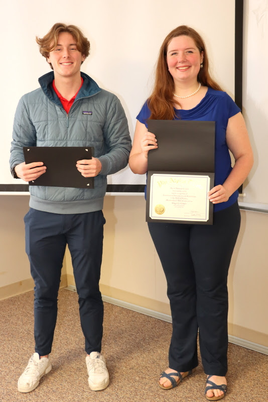 Abigail Gilbert stands with Delta-Psi President Tad Binkley after receiving her Phi Alpha Theta membership certificate at the chapter's spring plenary meeting on February 20, 2023.