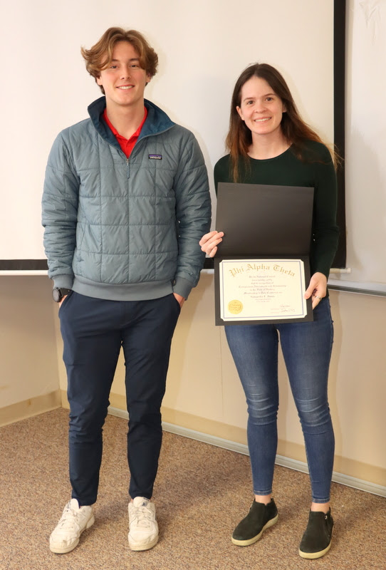 Samantha Poore stands with Delta-Psi President Tad Binkley after receiving her Phi Alpha Theta membership certificate at the chapter's spring plenary meeting on February 20, 2023.