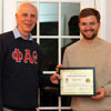Dr. Stephen Carls (left) gives Phi Alpha Theta member Luke Sower a certificate of appreciation at the history department cookout on May 11, 2019, for his work as the Delta-Psi chapter vice president in 2018-2019.